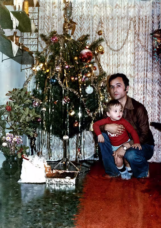 Photo restoration of a father and son crouching in front of a christams tree