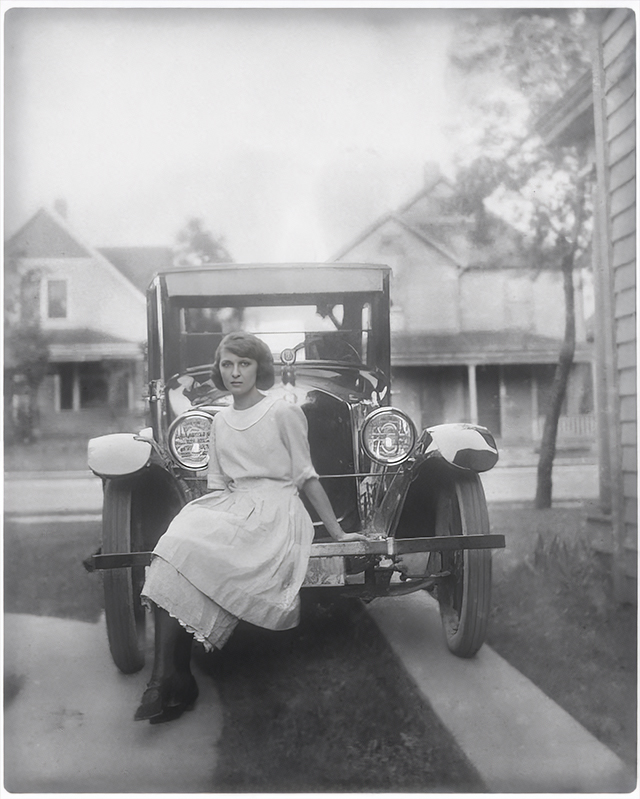 enhanced version of a photo restoration of young lady sitting on a car