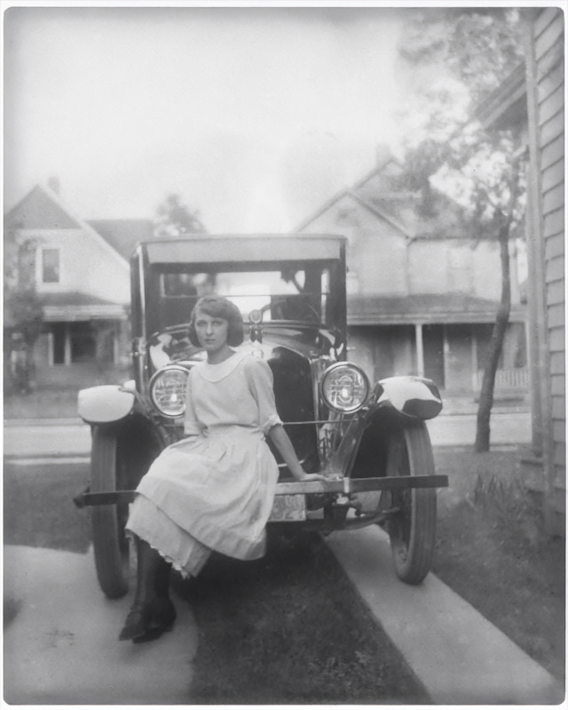 faithful restoration of a photo restoration of young lady sitting on a car