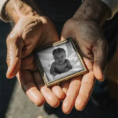 Restoring the Everyday Hero - The Hands That Held Us 1 a father holding a fathersday gift that is a restored photo of a damged photo that gopt repaired