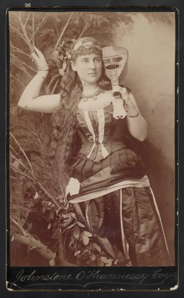 how-to-date-research-colourise-mystery-old-photos 9 Old Historical Photo with No Date It's of a woman standing there with some kind of guitar over her shoulder but it's not a guitar it's smaller