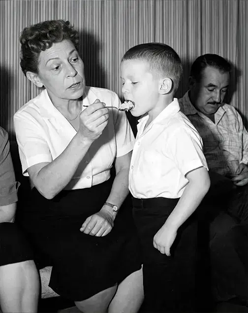 AI Restored Your Photo But It Looks Wrong? We Fix AI Restoration Mistakes 2 AI restored version of the same photo, where the woman now feeds the boy a spoonful of food and many details have changed
